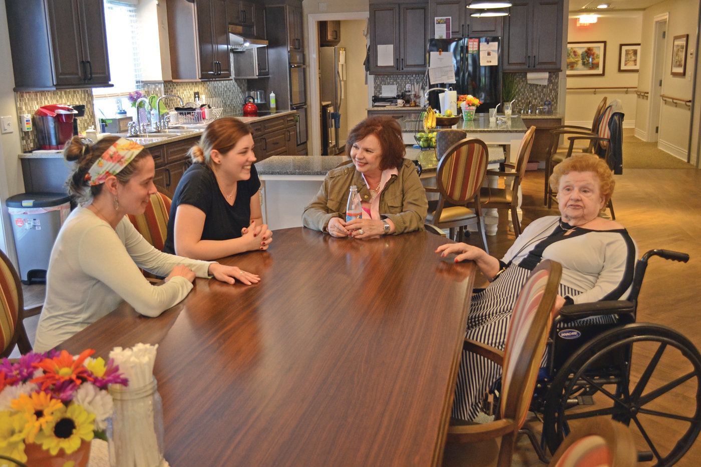 FAMILY ENVIRONMENT: Saint Elizabeth Green House home guide Sarah Bowater (left), Chrissy Yuras, Cheryl Prior and Green House home resident Claire Hill chat at the dinner table of one of Saint Elizabeth Community’s Green House homes.